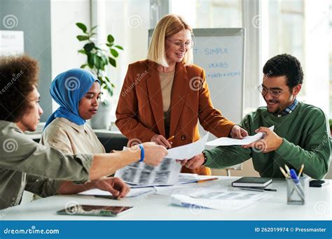 Happy Mature Teacher Passing Papers With Grammar Test Or Authentic Materials Stock Photo Image