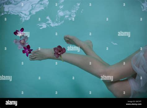 Gambe Nude E Piedi Di Donna Nuoto Sott Acqua In Piscina Termale Con Orchidee Foto Stock Alamy