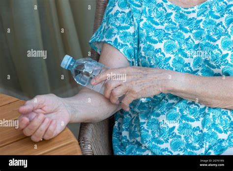 Senior Woman S Hand Holds Bottle With Cold Water On Her Elbow Bend How To Stay Cool In Hot