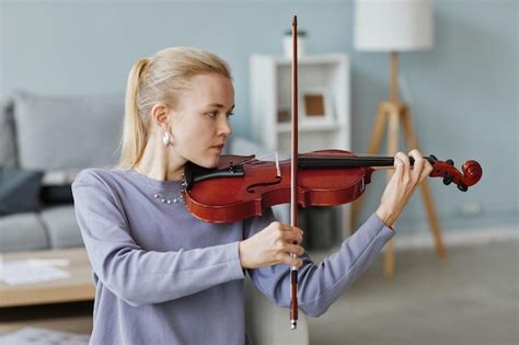 Premium Photo Side View Portrait Of Elegant Blonde Woman Playing Violin At Home Or In Music Studio