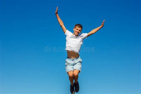 Happy Boy Jumping In The Blue Sky Concept Of Happiness Stock Photo