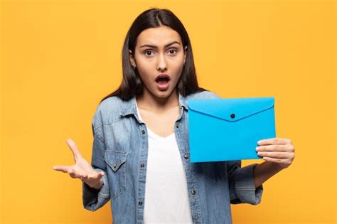 Joven latina boquiabierta y asombrada consternada y atónita con una sorpresa increíble Foto