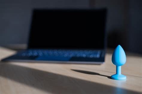 Enchufe anal de látex azul la computadora portátil sobre la mesa el