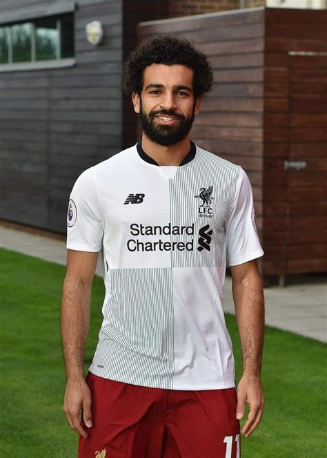 A Man With A Beard Wearing A White Shirt And Red Shorts Standing In