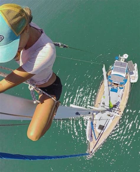 A Woman On A Sailboat In The Water Next To Another Person With A Hat