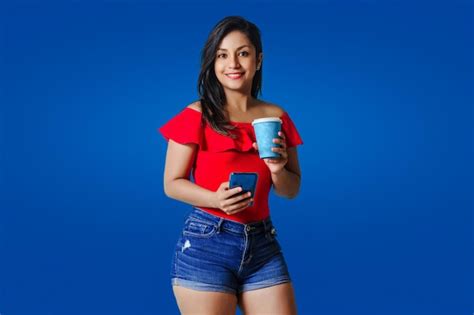 Retrato De Una Joven Latina Usando Un Tel Fono M Vil Con Una Taza De Caf Para Llevar Mirando A