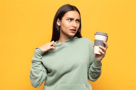 Joven latina sintiéndose estresada ansiosa cansada y frustrada tirando del cuello de la