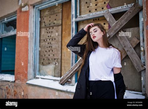 Fashionable Long Legs Brunette Model In Long Black Cloak Posed Outdoor At Winter Day Against Old