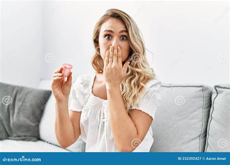 Jeune Femme Blonde Tenant La Coupe Menstruelle Couvrant La Bouche Avec La Main Choqu E Et