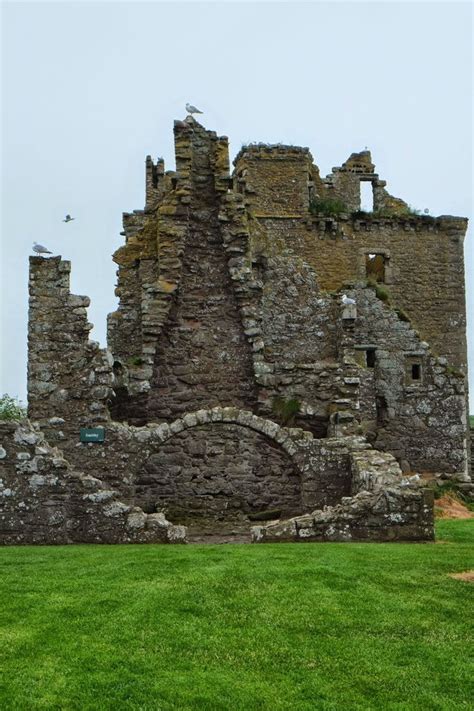 an old stone castle sitting on top of a lush green field