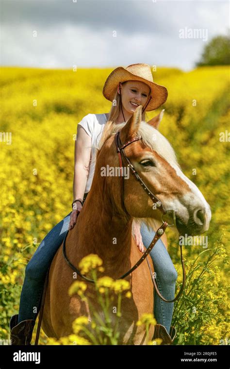Eine junge blonde Frau und ihr haflinger Pferd genießen ihre Zeit im Frühling draußen