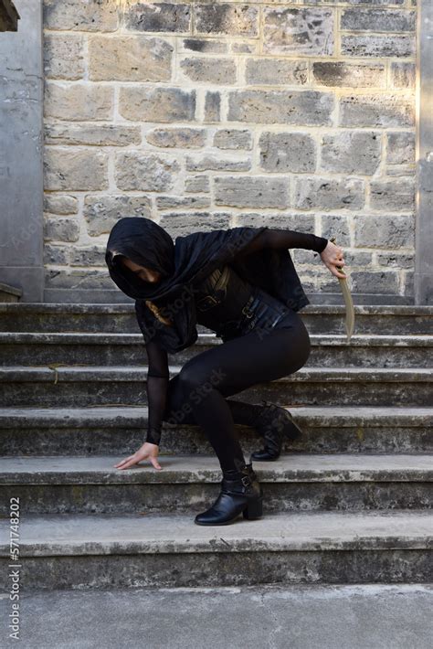 Portrait Of Beautiful Female Model With Blonde Plait Wearing Black Leather Catsuit And Flowing