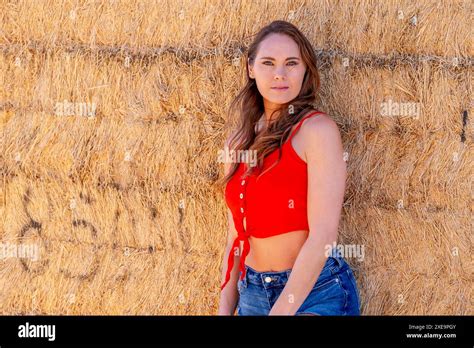 Brunette Beauty In Golden Fields A Captivating Pose Under Azure Skies Stock Photo Alamy