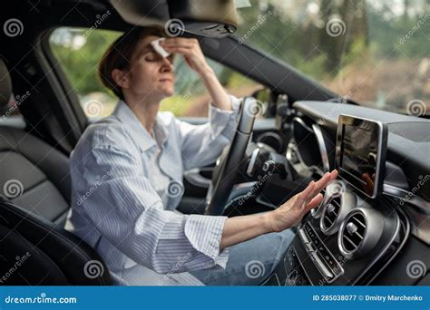 Woman Drives Car With Broken Air Conditioner In Hot Weather Wipes Sweat On Face Stock Image