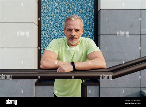 Mature Man Leaning On Railing In Front Of Building Stock Photo Alamy