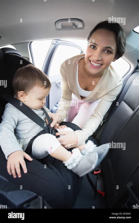 Mother Securing Her Baby In The Car Seat Stock Photo Alamy