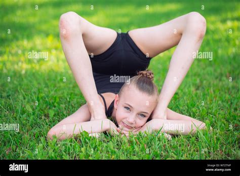 Beautiful Little Girl Doing Gymnastics On The Grass On A Sunny Day