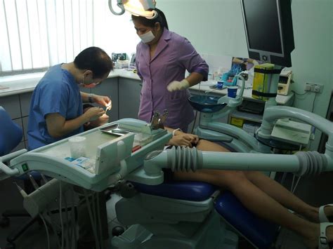 Two Dentists Working On A Woman S Leg In A Dental Room With Equipment