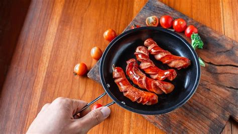 Saucisse Frite Dans Une Po Le Noire Entre Les Mains Du Chef Photo Premium