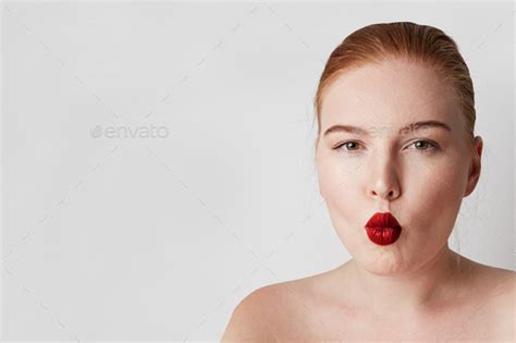 Handsome Redhead Female Model With Light Nude Make Up Posing Over White Background Stock Photo