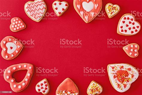 Frame With Glazed And Decorating Heart Shape Cookies On The Red