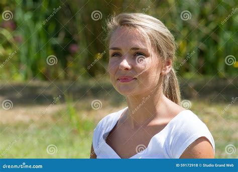 Plan Rapproché De La Fille 20s Blonde De Sourire Appréciant La Lumière Du Soleil Photo stock