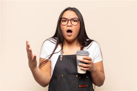 Joven latina que se siente extremadamente conmocionada y sorprendida ansiosa y en pánico con
