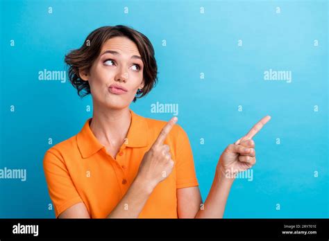 Photo Of Shiny Doubtful Lady Wear Orange T Shirt Pointing Two Fingers