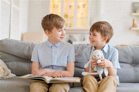 un hermano mayor le está leyendo un libro a su hermano menor sentado en