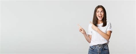 Premium Photo Attractive Smiling Brunette Girl Pointing Fingers Upper Left Corner Showing Logo