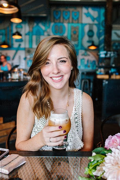 A Pretty Young Girl Enjoying An Iced Latte At A Coffee Shop Cafe By