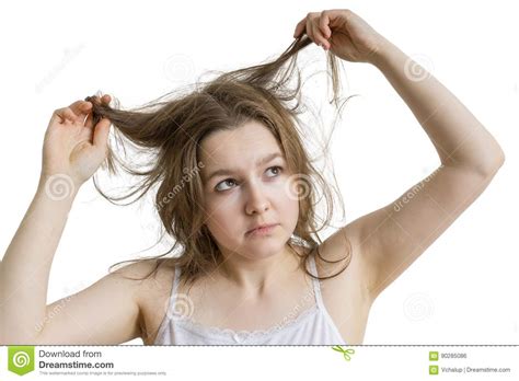 Young Unhappy Woman Is Looking At Her Damaged And Dry Hair Isolated On