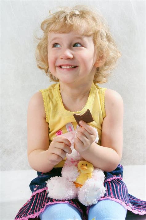 Petite Fille Bouclée Blonde Mangeant Du Chocolat Image stock Image du