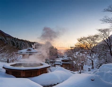 Steaming Japanese Onsen Hot Springs Nestled In A Snowy Landscape During A Quiet Winter Evening