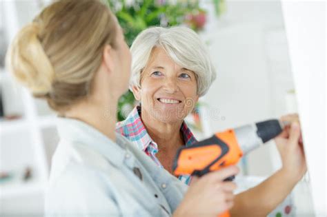 Smiling Blonde Granddaughter With Grandmother Reconstructing Home Interior Stock Photo Image