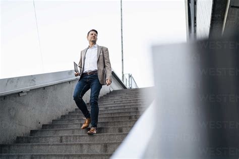 Businessman Walking Down Stairs Stock Photo