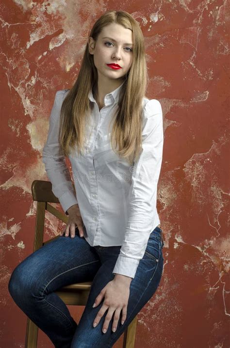 Jonge Slanke Mooie Jonge Blonde Vrouw Met Lange Benen En Haar In Tumultoverhemd En Jeans Stock