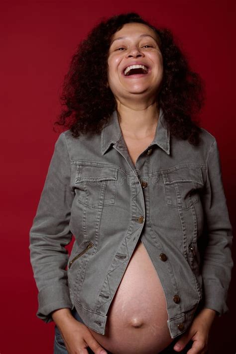 Happy Pregnant Woman With Naked Belly Wearing Stylish Casual Denim Blazer And Jeans Laughing