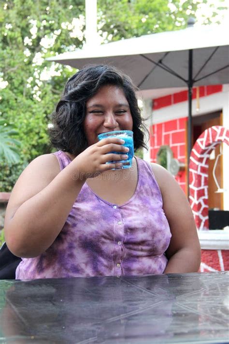 20 Year Old Latina Woman Drinks An Azulito Cocktail Or Alcoholic Drink With The Frosty Glass And