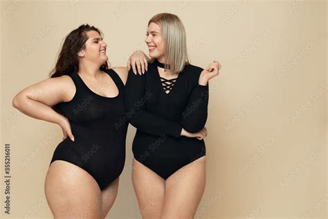 Plus Size Models Big Women Portrait Smiling Brunette And Blonde In Black Bodysuits Posing On