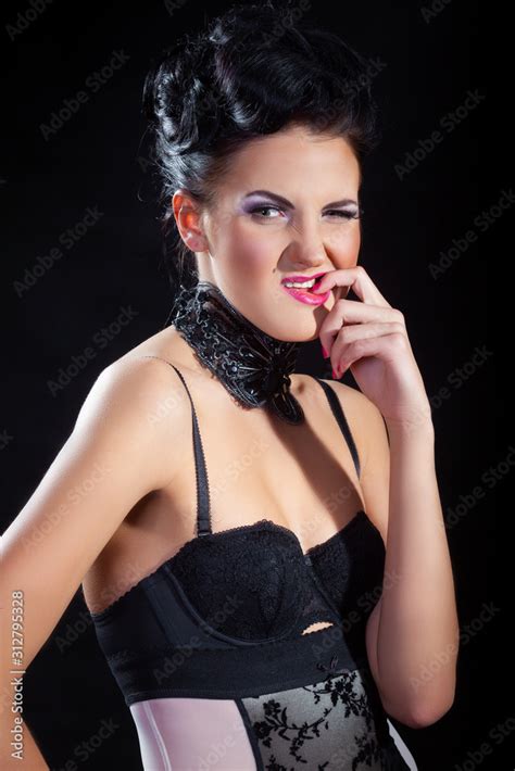 Attractive Female Model In Lingerie With Feathers Accessories Posing On Dark Studio Background