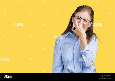 Beautiful Middle Age Mature Business Woman Wearing Glasses Over Isolated Background Smelling
