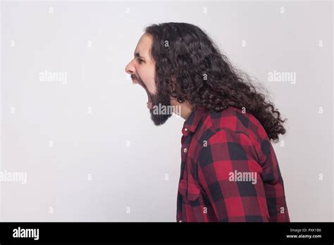 Profile Side View Portrait Of Handsome Angry Man With Beard And Black Long Curly Hair In Casual