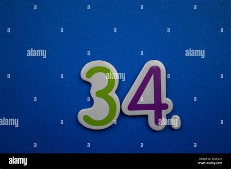 The Number 34 Placed On A Blue Background Photographed From Above