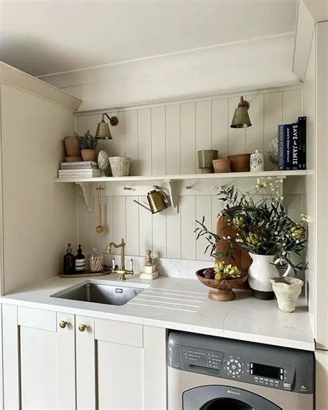 A Washer And Dryer Sitting In A Kitchen Next To A Counter With Flowers