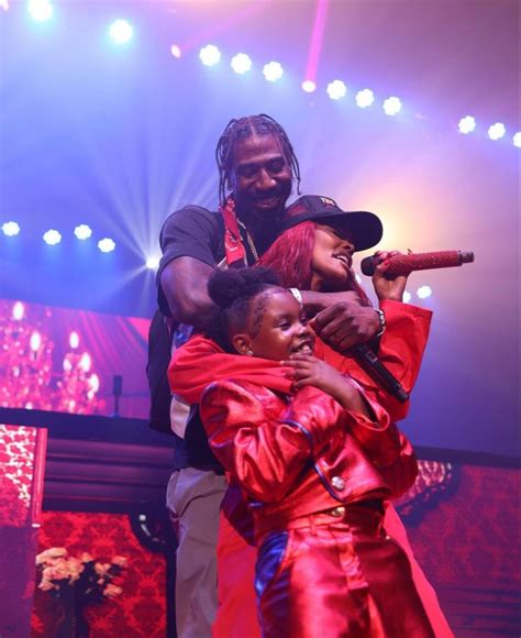 Two People On Stage Hugging Each Other With Bright Lights In The Back