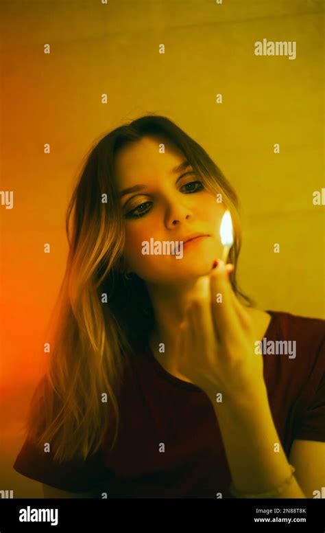 Portrait D Une Belle Femme Blonde Qui Regarde Un Match Br Lant Qu Elle Tient Dans Sa Main Dans