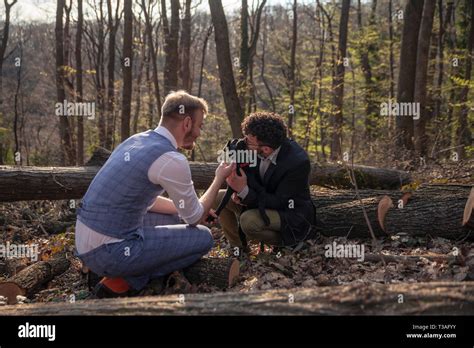Deux hommes couple gay câlins avec chien chiot L extérieur en bois le temps de loisir Photo