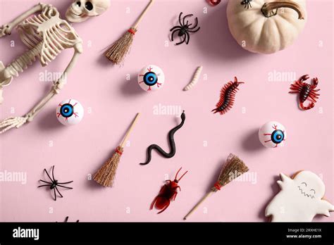 Halloween composition with candy bugs, skeleton and brooms on pink background Stock Photo - Alamy