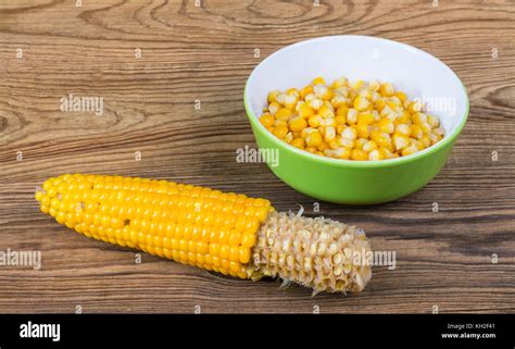 Partially Empty Corncob And Heap Of Boiled Maize Yellow Corn Grains In